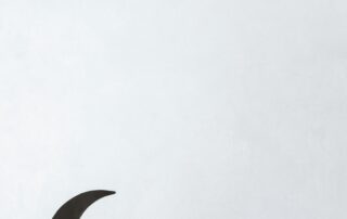 tulisan "Ramadan Mubarak" yang dihias dengan hiasan bulan sabit dan gantungan berwarna kuning. Tulisan dan hiasan ini diletakkan di atas latar belakang berwarna putih.