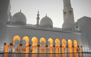 Masjid Sheikh Zayed di Abu Dhabi, Uni Emirat Arab. Terdapat kubah putih, arca, dan kolam dengan nuansa putih.