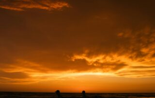 siluet tiga orang berjalan di tepi pantai saat matahari terbenam-Peran Keluarga
