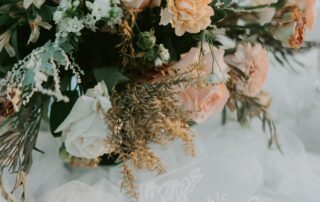 Center piece dengan vas berisi bunga mawar dan dahlia berwarna pastel. Ditambah dedaunan hijau dan kering menambah kesan romantis.